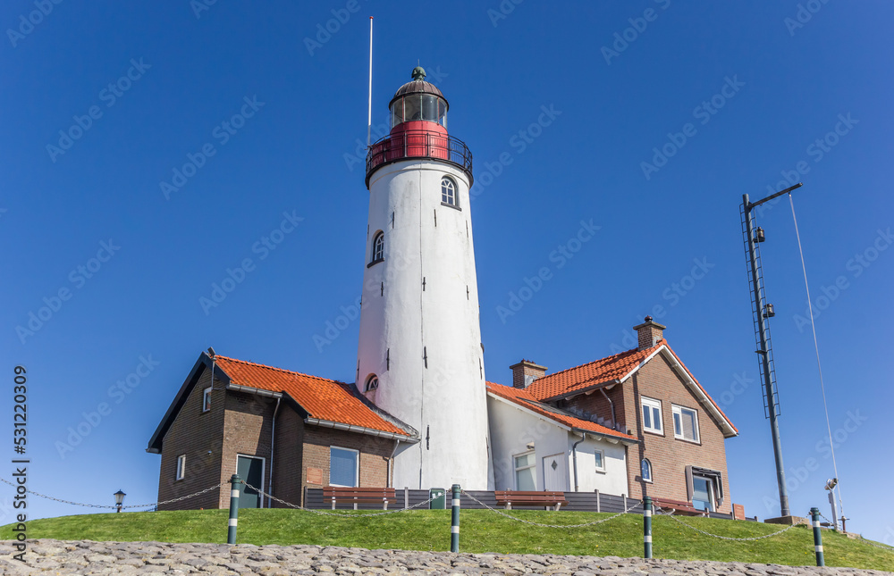 White lighthouse and houses on the top of the dike in Urk, Netherlands