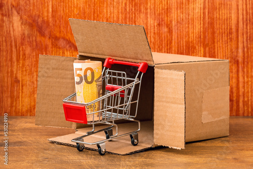 Mini shopping trolley comming out of cardboard box photo