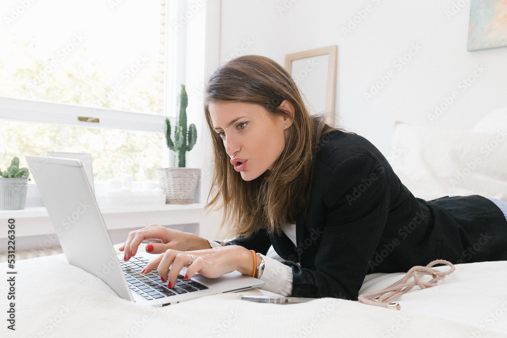 Young woman working with laptop on bed Young woman working with laptop on bed
