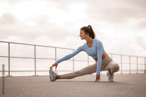 woman warming up before her morning workout. Training outdoors, healthy lifestyle concept.