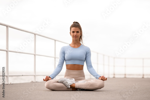 Great view of woman exercising and sitting in yoga lotus position