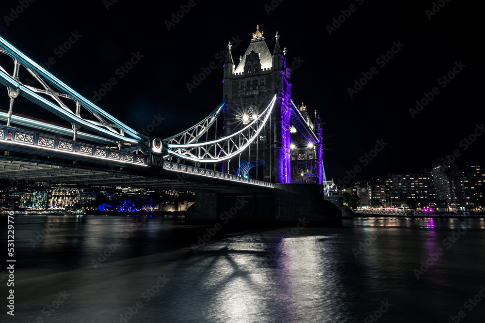 Obraz premium The Tower Bridge lit up in purple in the honour of Queen Elizabeth II