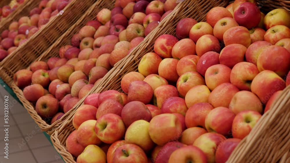Close-up of boxes of ripe red apples in a large grocery store in a hypermarket. Shelves with fruit. Close-up of boxes of ripe red apples in a large grocery store in a hypermarket. Shelves with fruit.