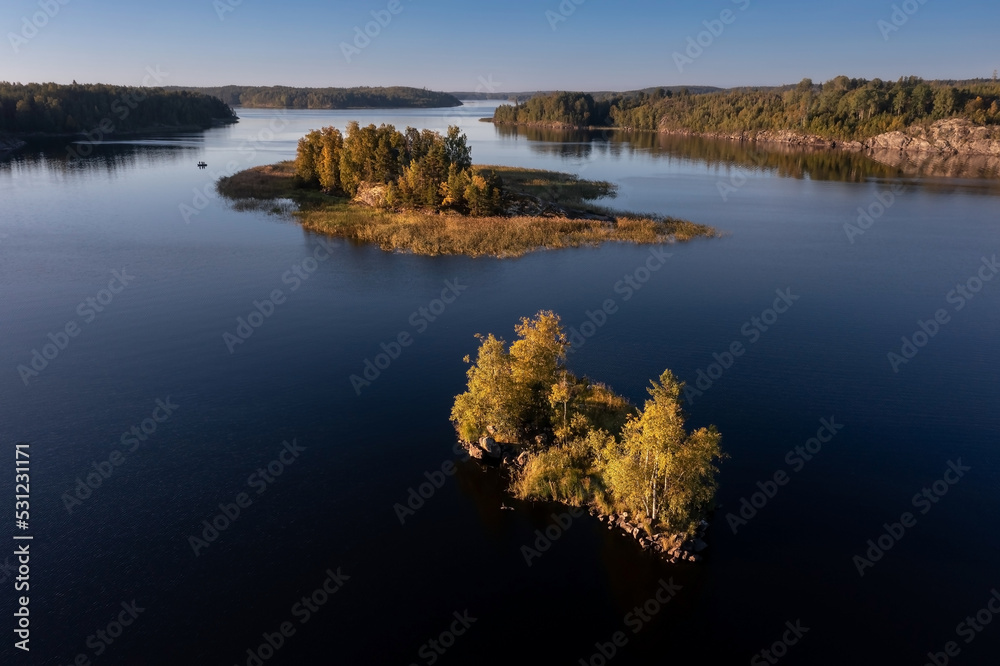 Small rocky island overgrown with trees in archipelago of many islands on Ladoga Lake Karelia Russia