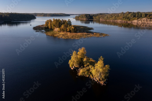Small rocky island overgrown with trees in archipelago of many islands on Ladoga Lake Karelia Russia