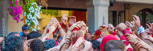 CAMBRILS, SPAIN - SEPTEMBER 04.2022: Hands at a Castells Performance, a castell is a human tower built traditionally in festivals, panorama photo