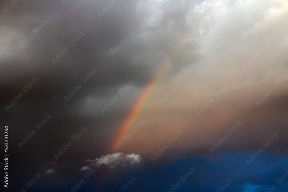 Beautiful rainbow in a cloudy sky with clouds	
