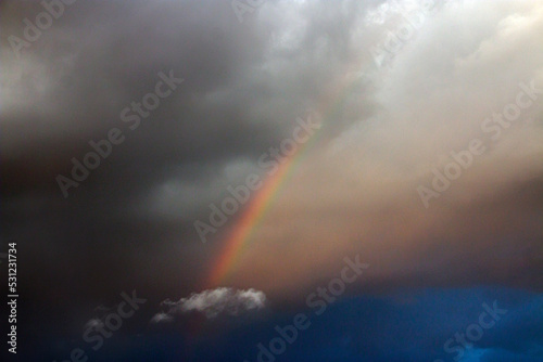 Beautiful rainbow in a cloudy sky with clouds 