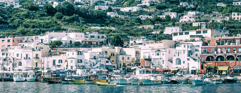 Panoramic view of Capri Island restaurants and shops along the port promenade, Italy