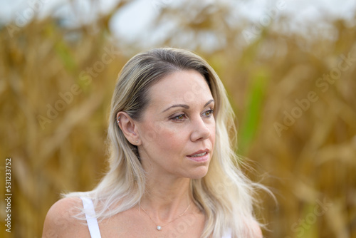 Beautiful lond woman standing in a corn field photo