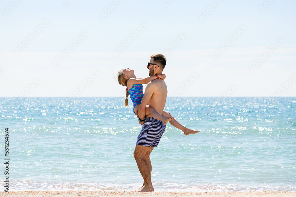 Young father play with daughter at sea beach Young father play with daughter at sea beach