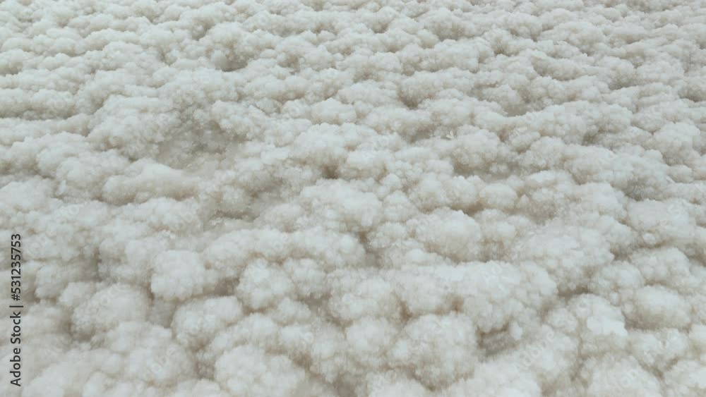 Camera moves over white crystalline salt Closeup detail on Ein Bokek beach at Dead Sea - world most hypersaline lake Camera moves over white crystalline salt Closeup detail on Ein Bokek beach at Dead Sea - world most hypersaline lake