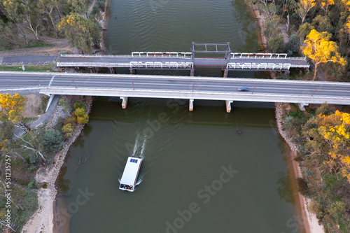 Aerial view of bridges crossing a wide river with a house boast passing underneath photo