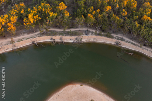 Aerial view of a bend in a river with a sandy beach and surrounding bush photo