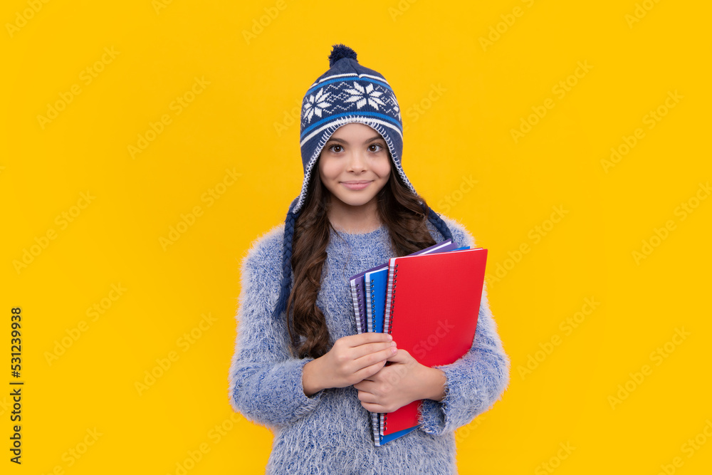 Autumn school. Teenager school girl with books in autumn clothes on yellow isolated studio background. Happy face, positive and smiling emotions of teenager schoolgirl. Autumn school. Teenager school girl with books in autumn clothes on yellow isolated studio background. Happy face, positive and smiling emotions of teenager schoolgirl.