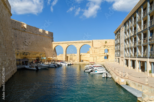 The Wet Ditch and aqueduct in-between Fort St Angelo and apartment building in Birgu (Vittoriosa), Malta.