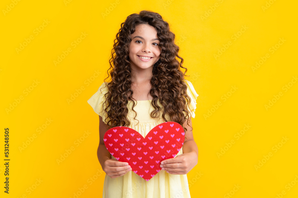 Lovely teenager portrait. Teenage girl hold shape heart, heart-shape sign. Child holding a red heart love holiday valentine symbol. Smiling girl.