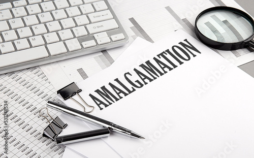 AMALGAMATION text on paper with chart and keyboard, business concept
