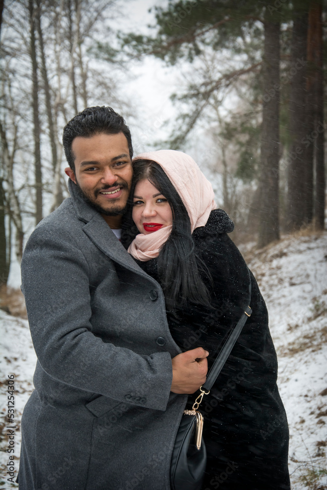In winter, on a frosty day in the forest, a couple in love hugs. In winter, on a frosty day in the forest, a couple in love hugs.