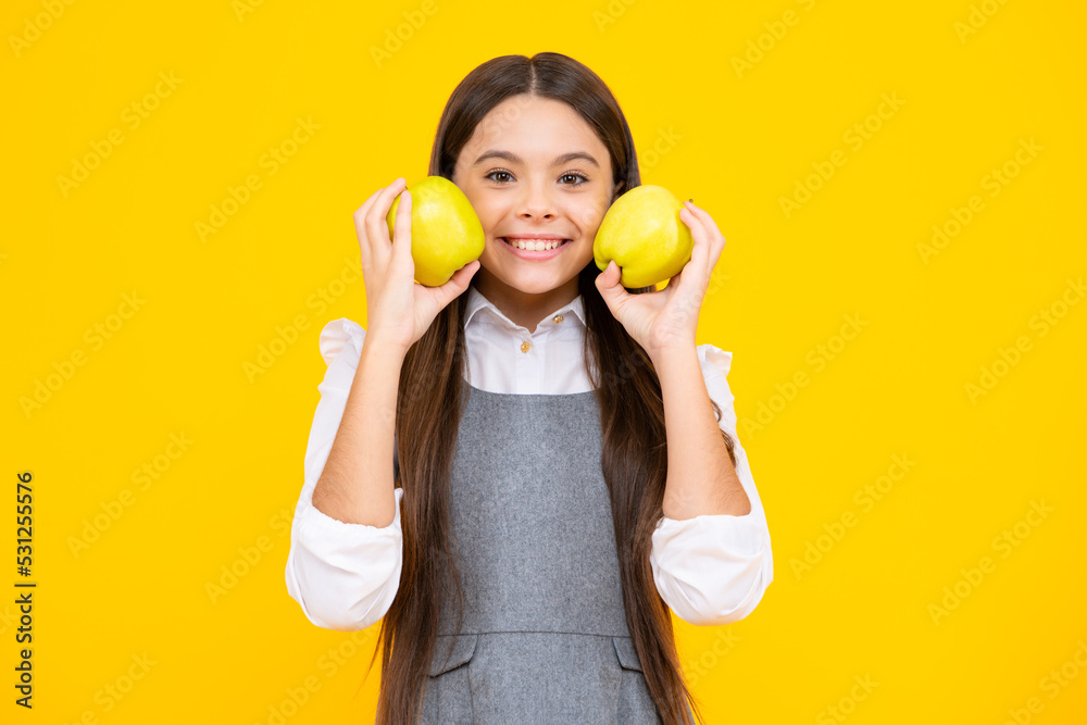 Child girl eating an apple over isolated yellow background. Tennager with fruit. Child girl eating an apple over isolated yellow background. Tennager with fruit.
