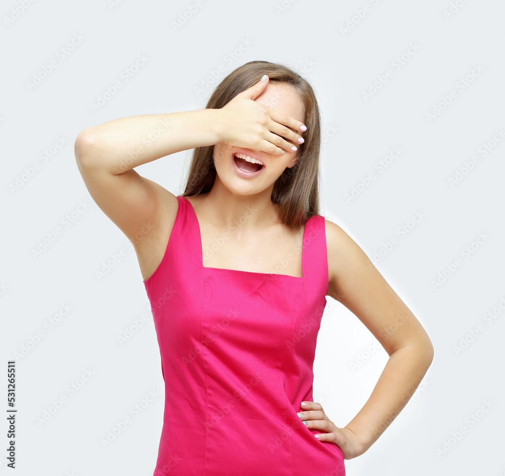 Portrait of young woman covering her face with hands.Girl peeking through fingers Portrait of young woman covering her face with hands.Girl peeking through fingers