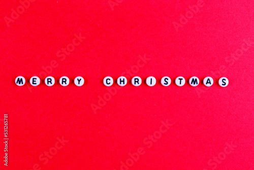 Lettering WITH MERRY CHRISTMAS on a red paper background. New Year's card, banner