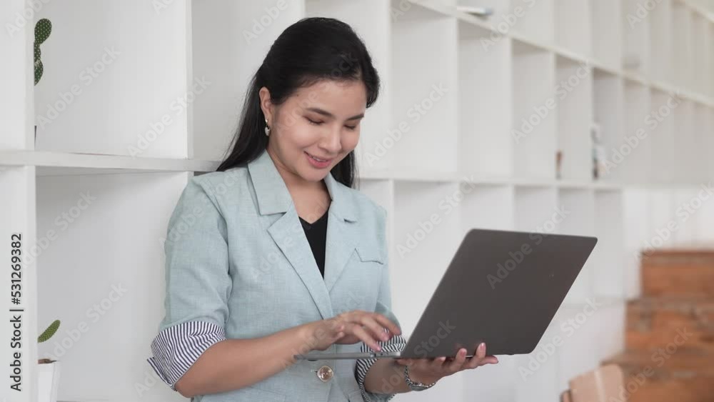Photo of joyful nice woman using laptop and smiling while sitting.