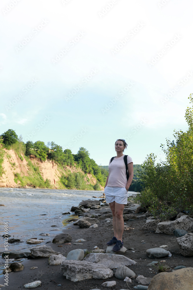 Woman standing on bank of Belaya River in evening