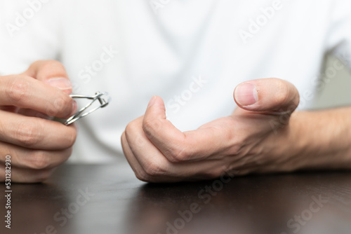 Close up male hands cutting nails with clippers