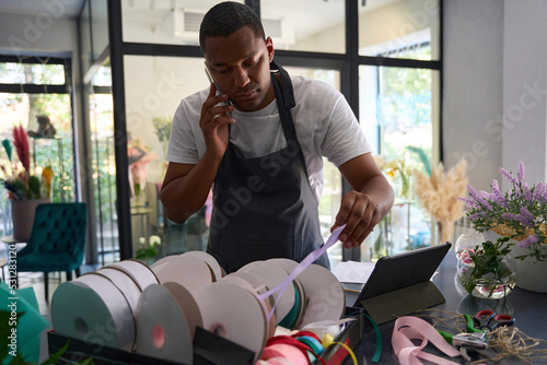 african american man in a flower shop talking on the phone