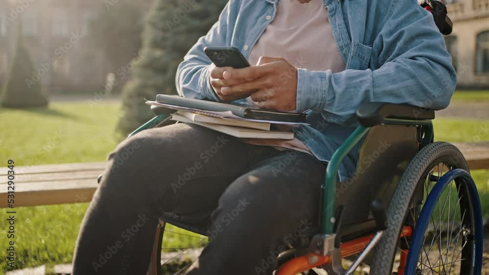 Disabled man sits in wheelchair checking social networks Disabled man sits in wheelchair checking social networks