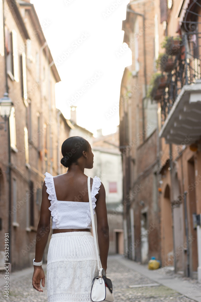 Portrait of African American woman dressed in white getting to know Europe, Ferrara. Italy