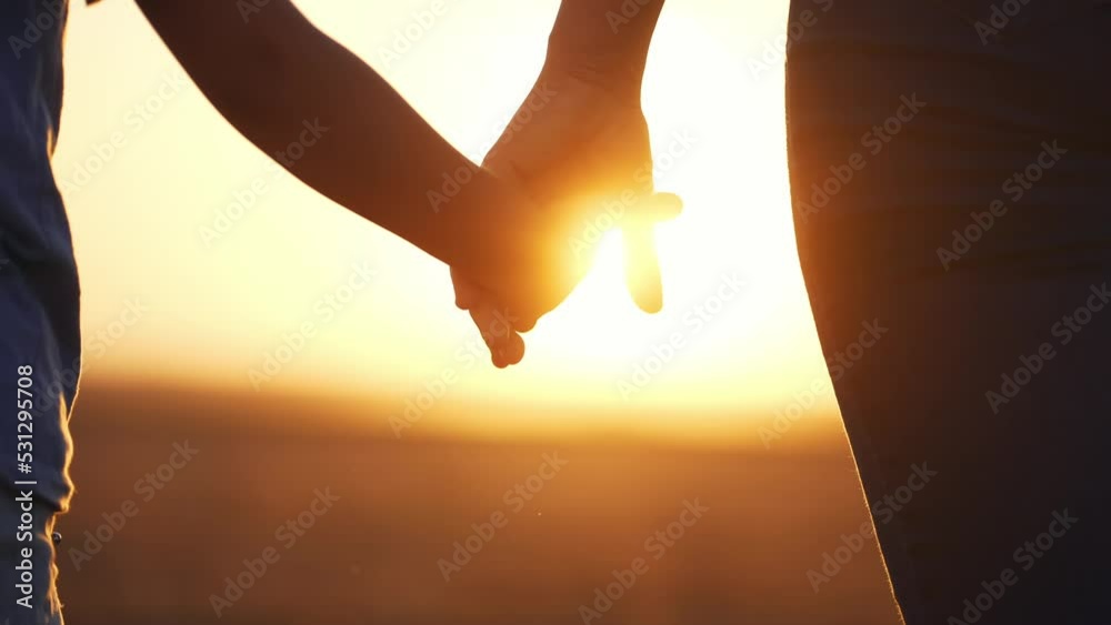 happy family. mom and daughter hold hands close up. mother and baby girl hands together at sunset. parent girl and child happy childhood. lifestyle happy family mothers day together concept