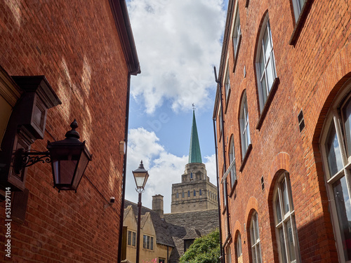 Bulwarks Lane with red brick buildings and the view of the tower and the spire of Nuffield College. Oxford, England, UK, Europe photo