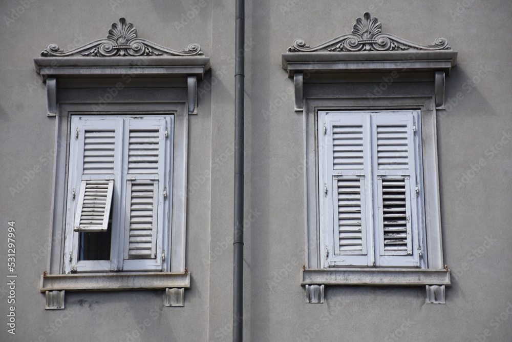 Fototapeta premium Two white windows on a gray building