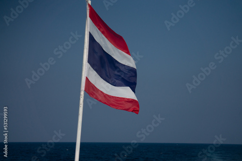 The flag of Thailand is hanging on a pole.