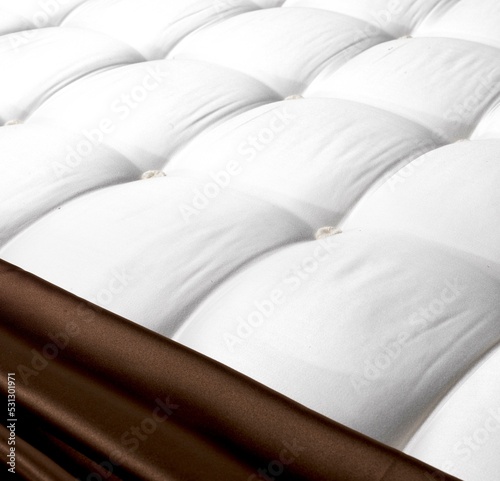 Top view handmade  brown mattress , close up mattress with , background of comfortable bed , quilted white fabric .