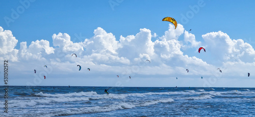 Cometas de Kai Surf en un día soleado y lleno de grandes nubes en una playa española