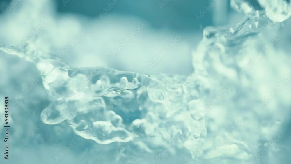 A mountain river with crystal clear water. Well water is flowing over stones. Abundant blue stream in a forest. Cold water splashing near rapids. Concept of mineral water. Super slow motion shot
