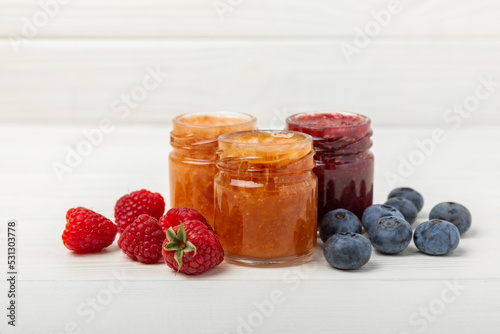 Jar of honey. Fruit honey with raspberries and blueberries.Useful fortified beekeeping product for health and beauty.Cream honey.Vegetarian diet organic product.Copy space. place for text