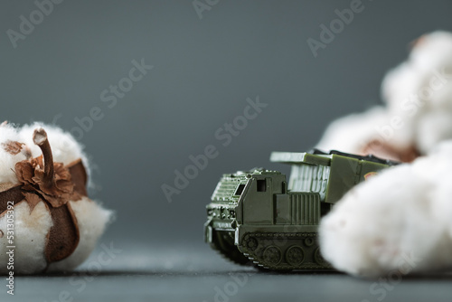 Model toy of Multiple Launch Rocket System or MLRS firing cotton flowers. Trendy Ukrainian banter about russian propaganda. Peace and no war concept. Macro shot. Bavovna is cotton in Ukrainian. photo