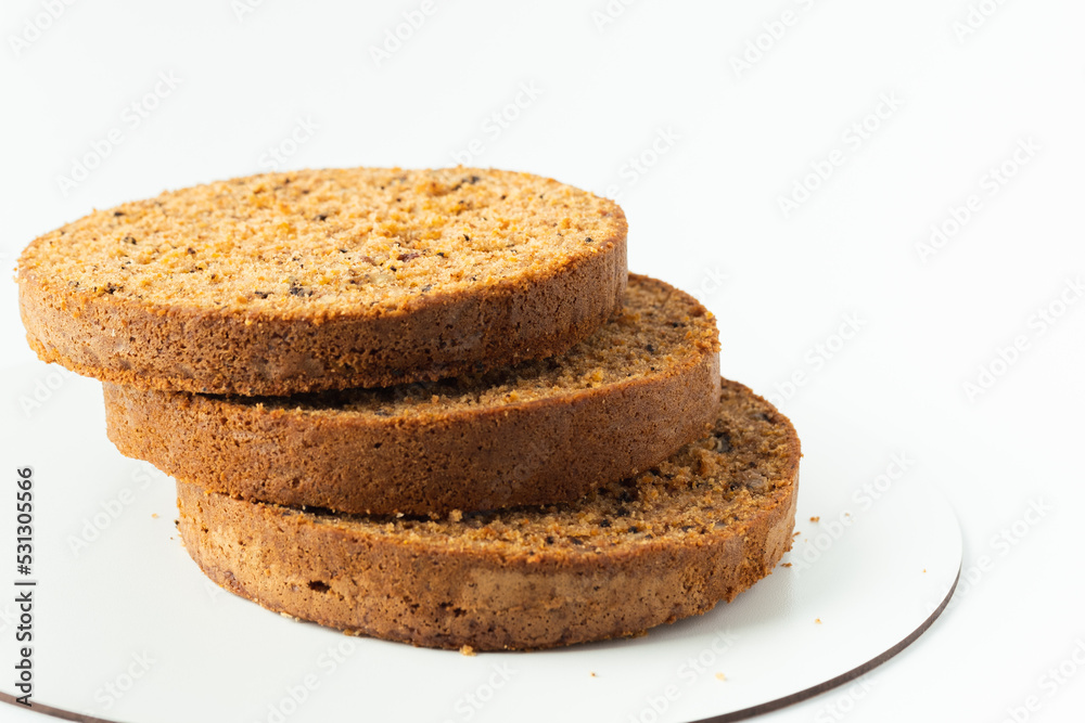 Carrot cake sponge biscuit cut into round slices for cake layers. cake ingredients on white background. Making cake Carrot cake sponge biscuit cut into round slices for cake layers. cake ingredients on white background. Making cake