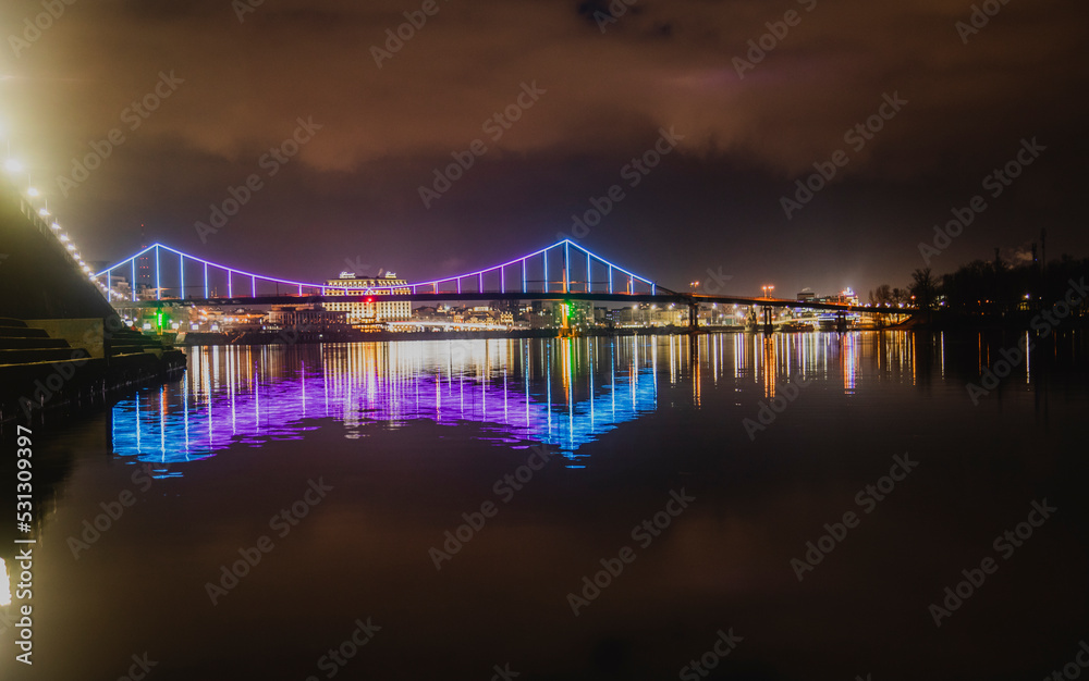 KIEV, UKRAINE - JANUARY 6, 2020: PARK BRIDGE (pedestrian bridge) ILLUMINATED BY NIGHT