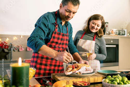 Happy man and woman cooking together traditional dinner for Christmas at home kitchen