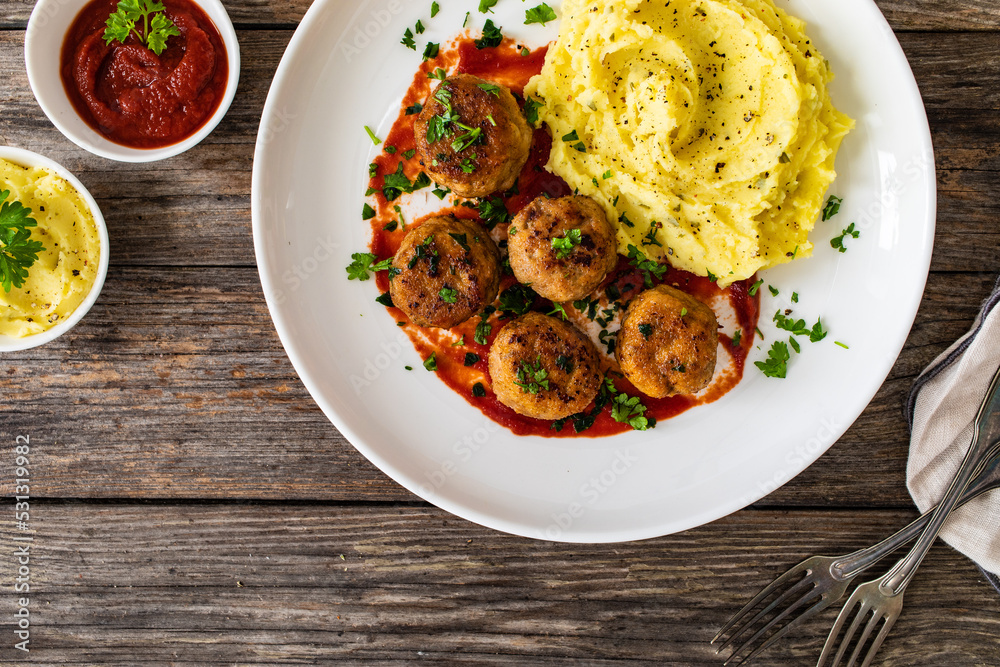 Fried pork meatballs with potato puree and tomato sauce on wooden table
Fried pork meatballs with potato puree and tomato sauce on wooden table