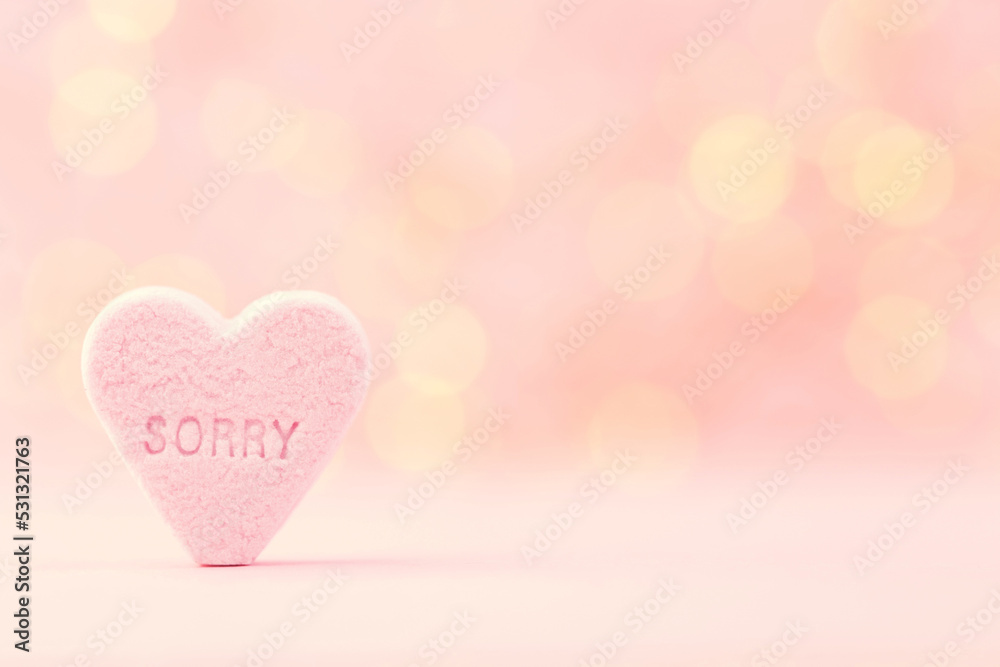Pastel colored candy hearts in a bokeh background.