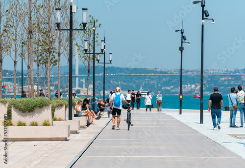 A sporty man with bicycle walking along the embankment. Healthy lifestyle