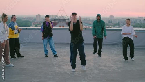 young people are dancing modern street dance on roof, breakdance and hip-hop choreography