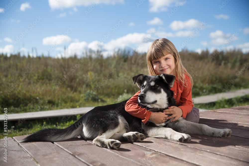 child girl hugs puppy near house in village on autumn afternoon
child girl hugs puppy near house in village on autumn afternoon