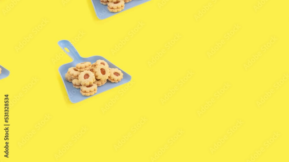 Creative food concept with dustpan and cookies on yellow background 4k. Creative food concept with dustpan and cookies on yellow background 4k.